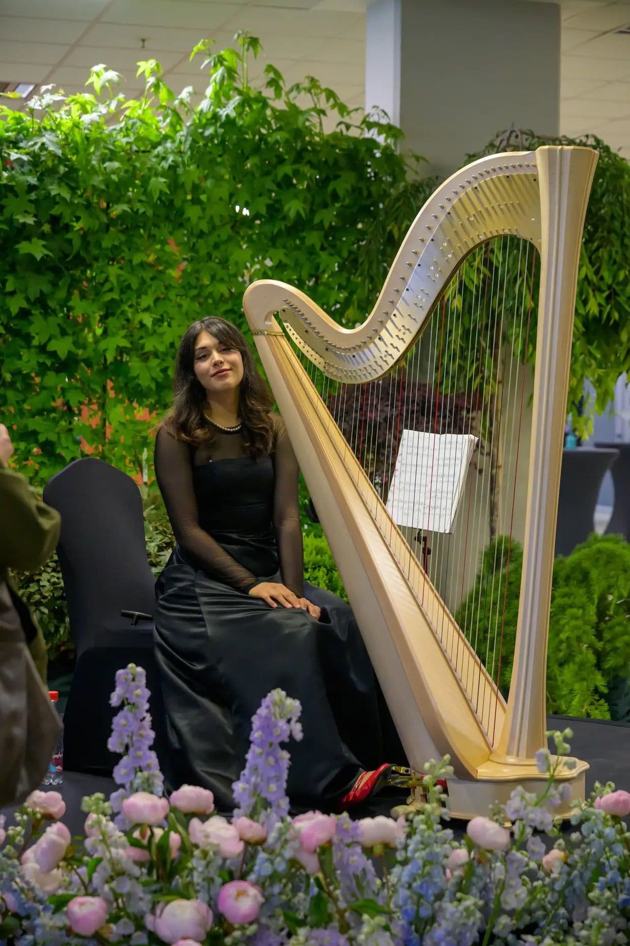 Alexandrina posing with harp in a floral setting